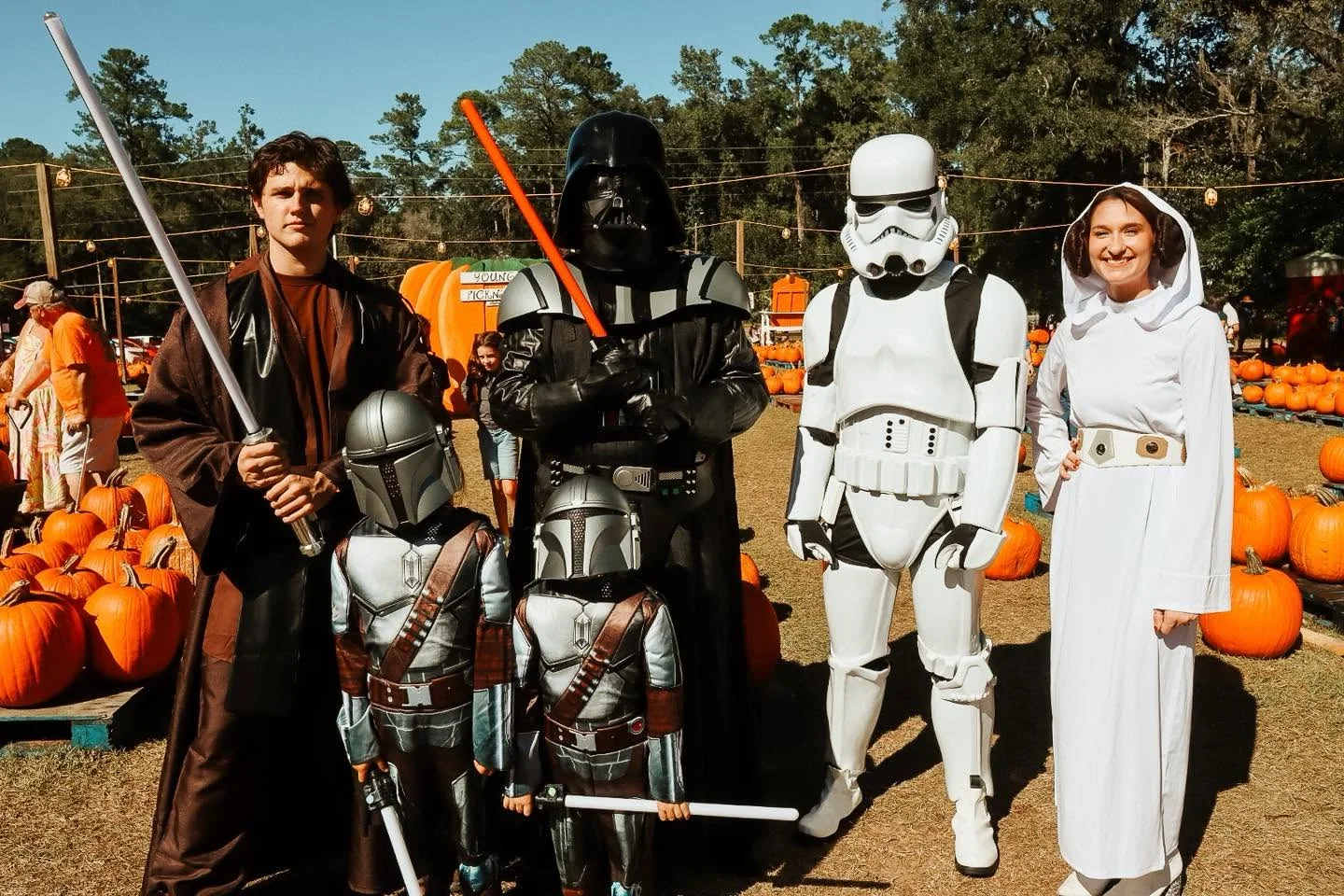 Costumed guests posing together at a past pumpkin patch season